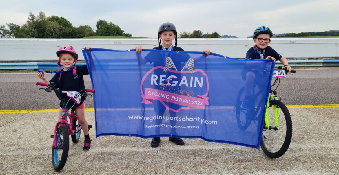 Scouts holding a banner for Regain Sports cycling event